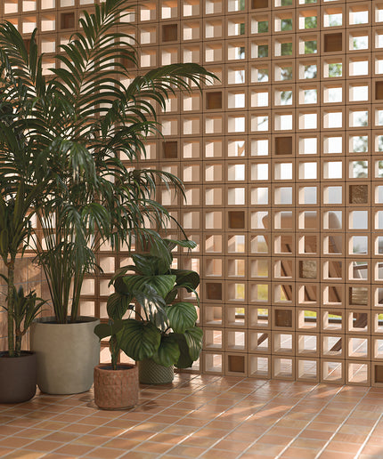 Potted plants in front of a textured brick wall