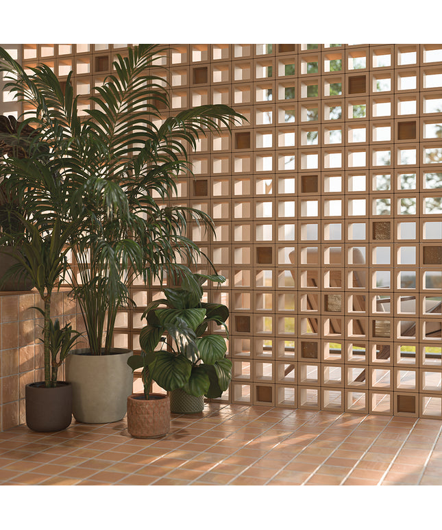 Potted plants in front of a textured brick wall