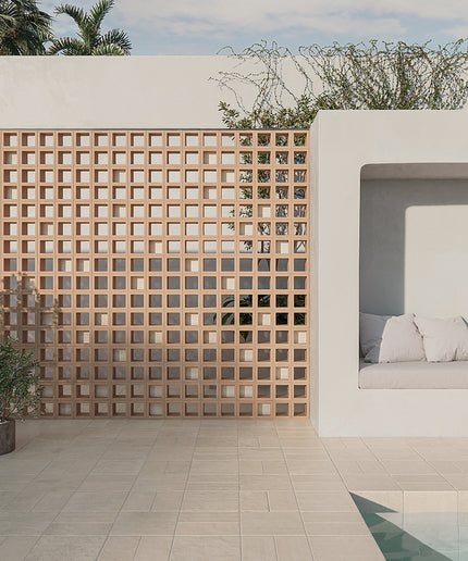 Modern outdoor setting with a geometric wooden screen, white sofa, and pool.