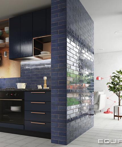 Modern kitchen with dark blue cabinets and a living room with a plant.