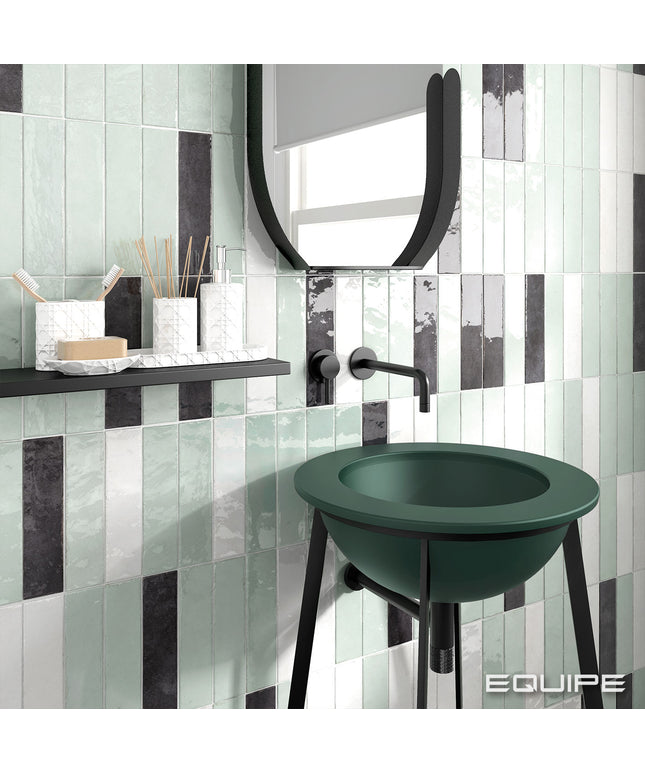 Bathroom with green sink against a tiled wall, featuring the brand 'EQUIPE'.