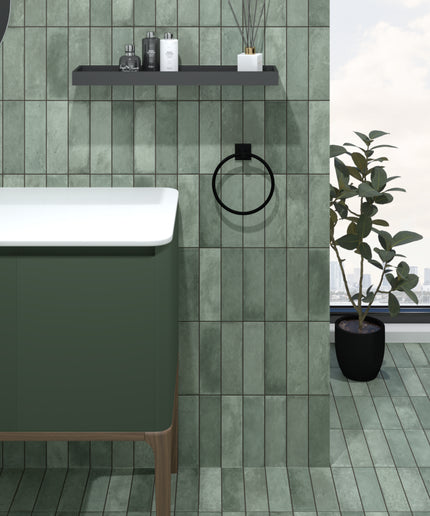 Modern bathroom with vertical green tiles, floating vanity, black fixtures, and large window.