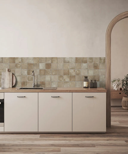 Beige square ceramic tile backsplash in modern kitchen with wood countertop and neutral cabinets