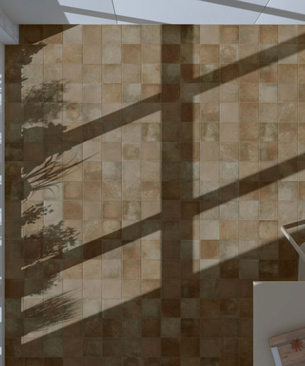 Terracotta square floor tiles in a sunlit room with large windows and indoor plants