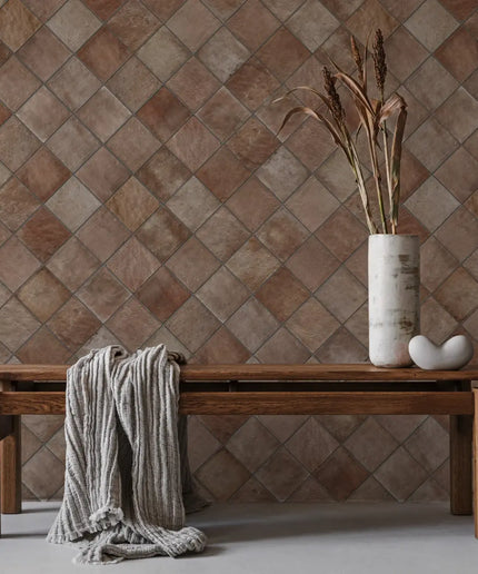 Terracotta square wall tiles in diamond pattern with rustic wood bench decor