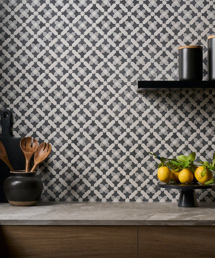 Kitchen counter with decorative elements against a patterned wall.