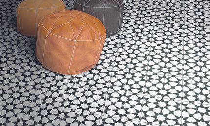 Black and white geometric floor tiles with round leather poufs, modern interior decor