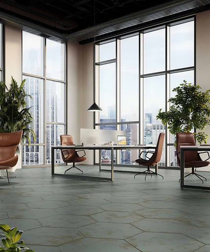 Modern office space with large windows, desks, and chairs.