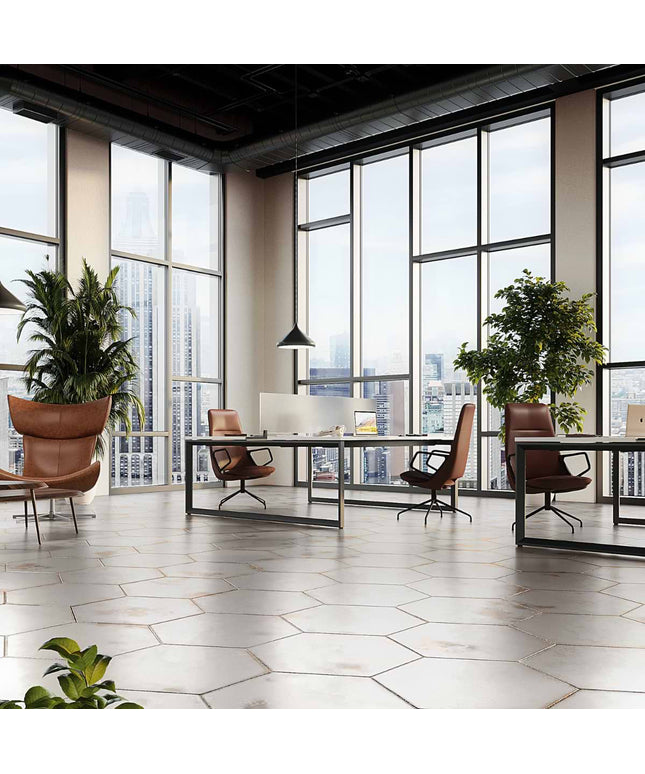 Modern office space with large windows, desks, and chairs.