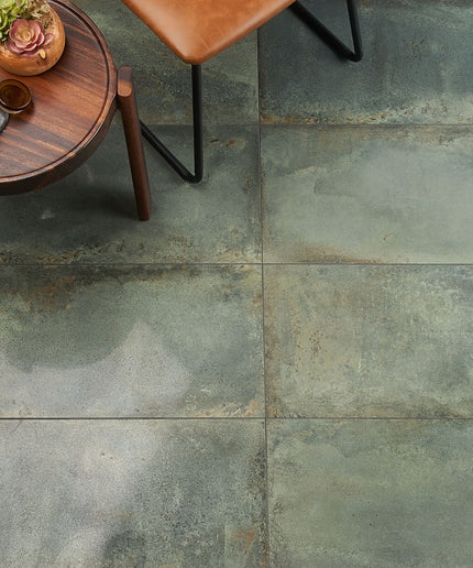 Close-up of a stone-tiled floor with a wooden side table and chair.