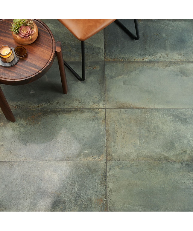 Close-up of a stone-tiled floor with a wooden side table and chair.