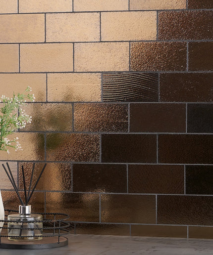 Decorative wall with brown and beige tiles, featuring a vase with flowers and a diffuser.