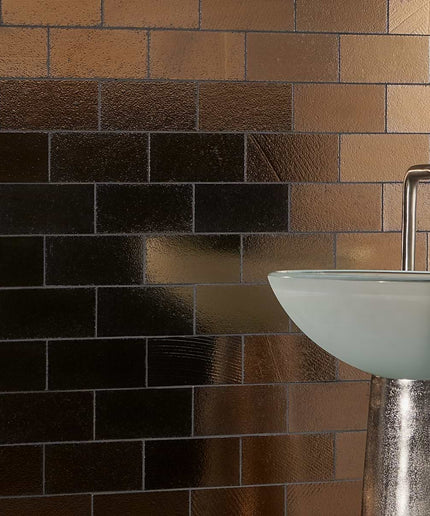 Bathroom sink with metallic faucet against a brick-patterned wall.