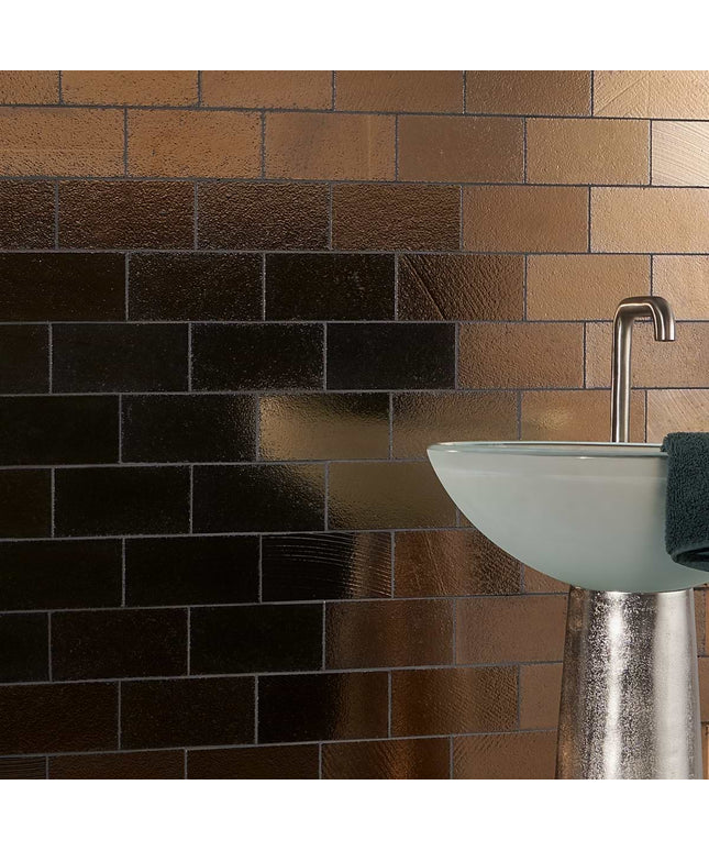 Bathroom sink with metallic faucet against a brick-patterned wall.
