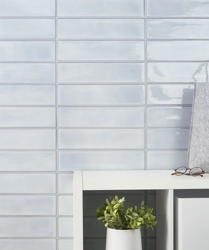 Glossy light blue rectangular wall tiles in a modern interior with shelf decor