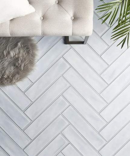 Azure matte herringbone tile floor with bench, faux fur rug, and plant decor