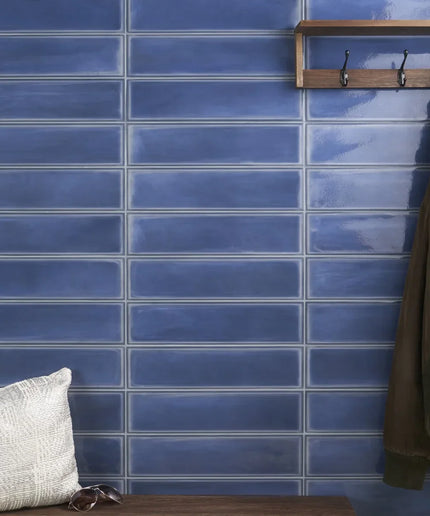 Glossy denim blue 4x16 subway tiles on wall, modern decor style, with wooden shelf and hooks