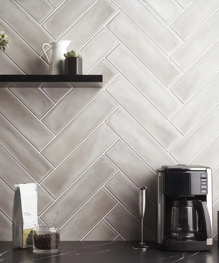 Matte gray herringbone kitchen backsplash tiles with coffee station and shelf decor