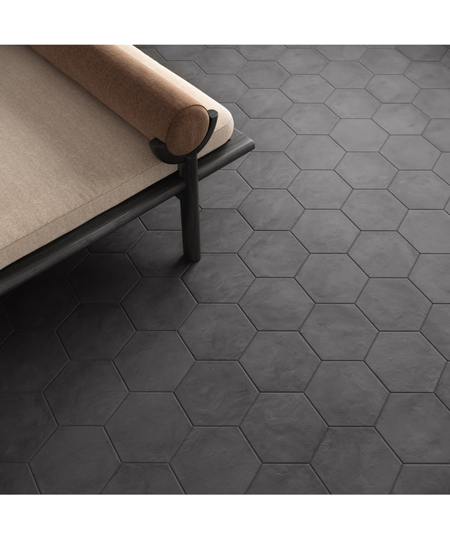 Hexagonal black tiles on a floor with a beige sofa.