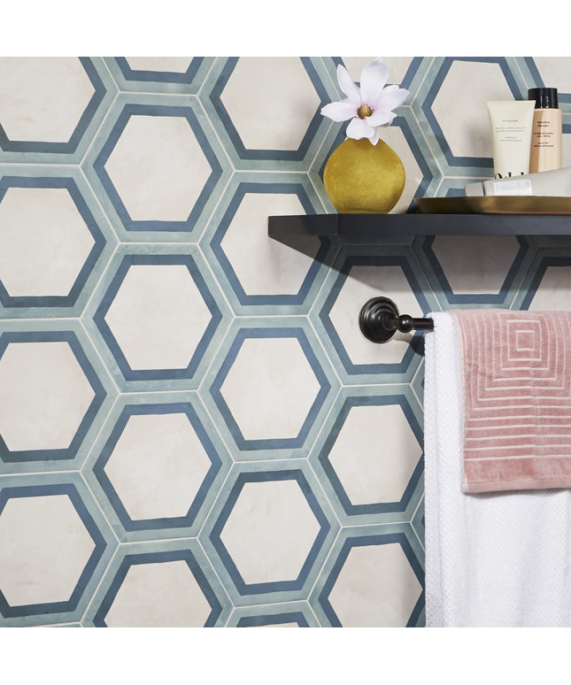 Hexagonal patterned tiles in a bathroom setting with a shelf and decorative items.