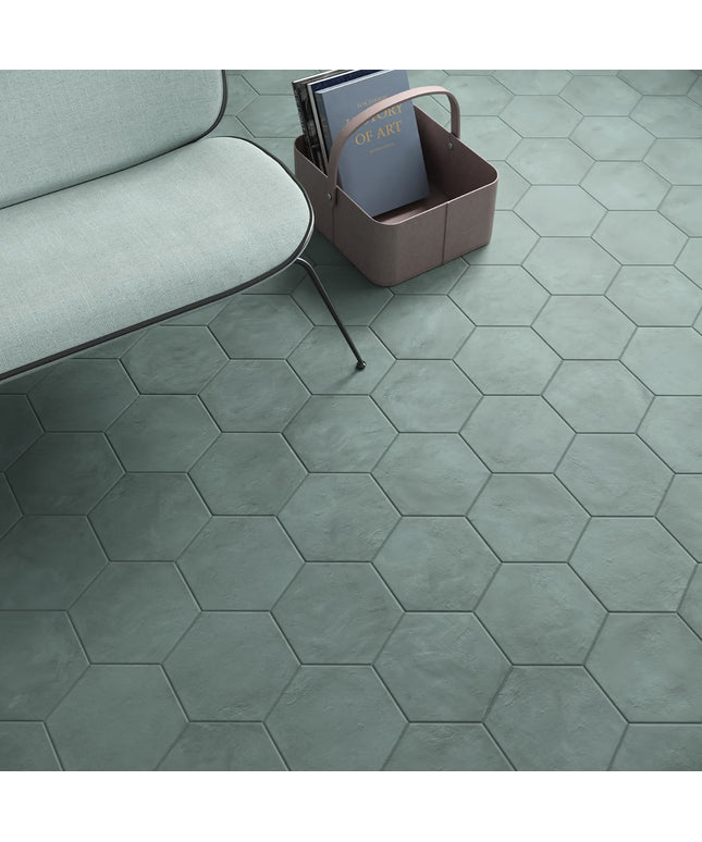Hexagonal green tiles on a floor with a sofa and basket in the background