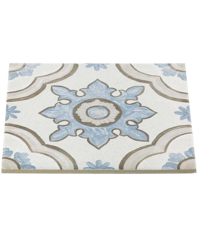 Decorative encaustic tile with blue and beige pattern on a white background