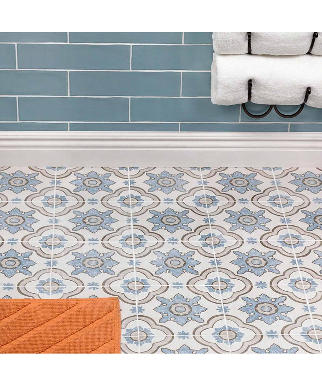Bathroom with blue tiled wall and patterned floor tiles.
