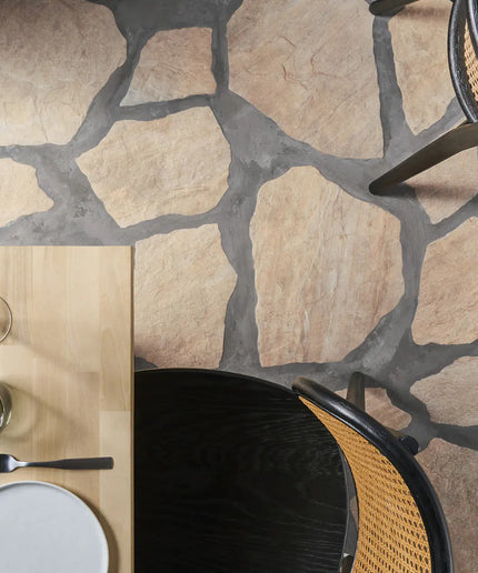 Top-down view of a stone-patterned floor with a table setting and chairs.