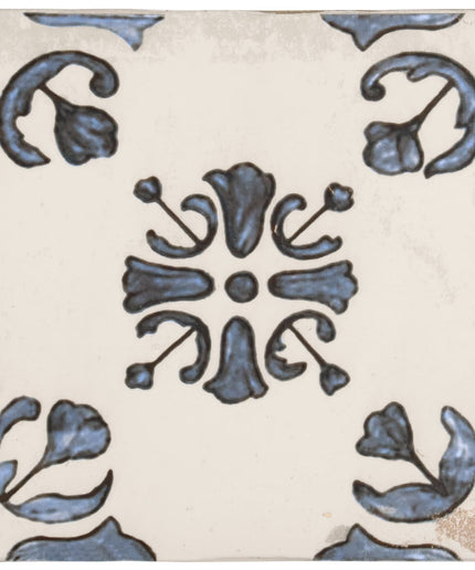 Decorative ceramic tile with blue floral and scroll pattern on a cream background