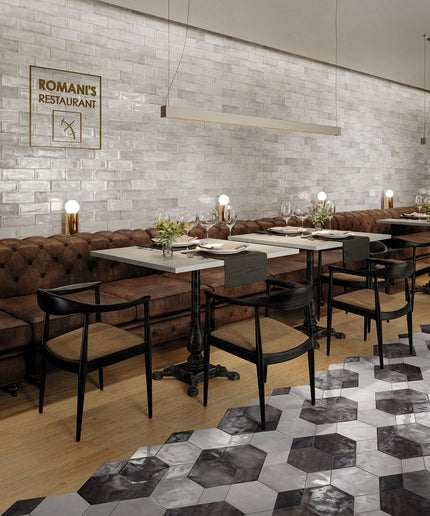 Modern restaurant interior with tables, chairs, and a decorative wall sign.