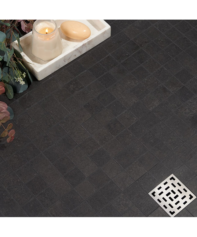 Dark tiled floor with a small white tray holding a candle and soap, next to a decorative plant. made in the USA