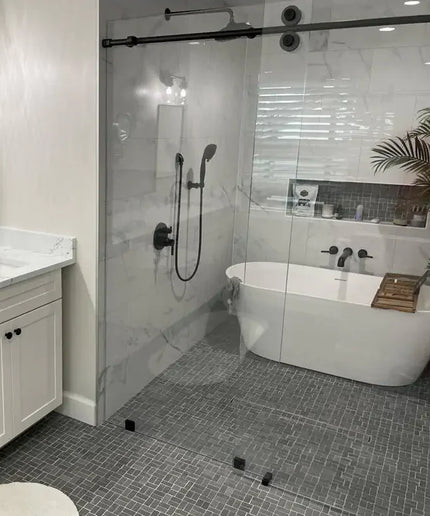 Modern bathroom with black lava antique natural stone tile floors, glass shower, and freestanding tub
