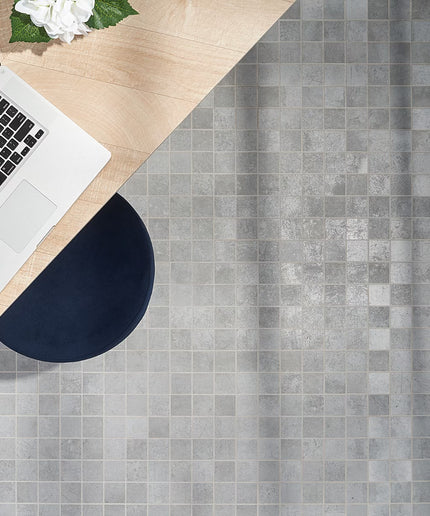 Laptop on a wooden desk with a gray tiled floor