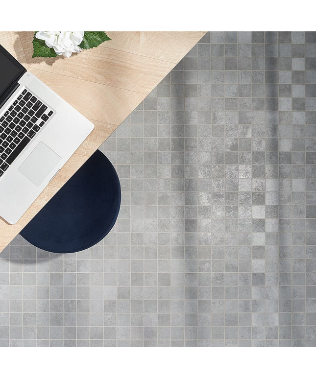 Laptop on a wooden desk with a gray tiled floor