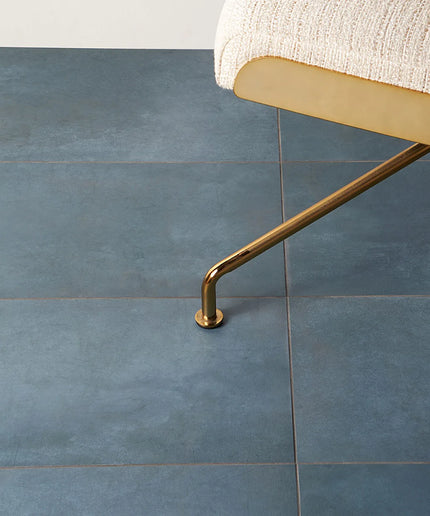 Gold chair leg on a blue tiled floor