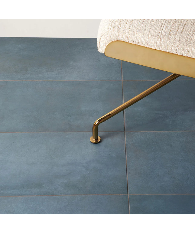 Gold chair leg on a blue tiled floor