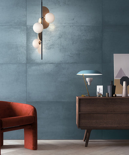 Modern interior with a red armchair, wooden sideboard, and decorative items against a blue wall.