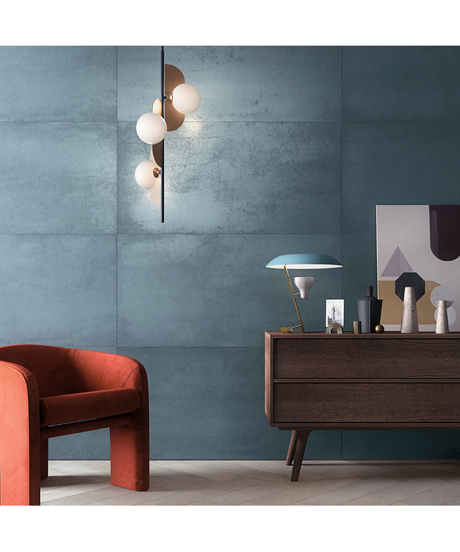 Modern interior with a red armchair, wooden sideboard, and decorative items against a blue wall.