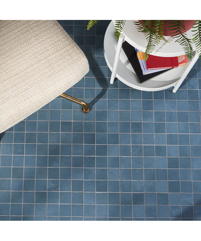 Blue tiled floor with a chair and small table in the corner