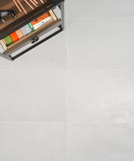 Wooden drawer with stationery items on a light gray floor