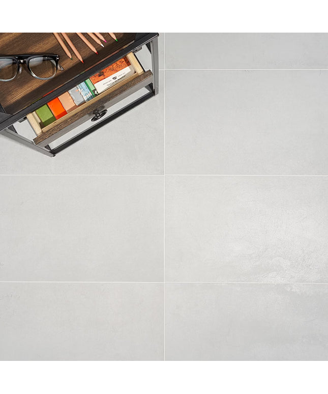 Wooden drawer with stationery items on a light gray floor