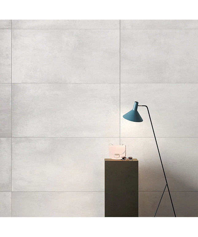 Modern interior design with a blue lamp and pink bag on a wooden stand against a gray tiled wall.