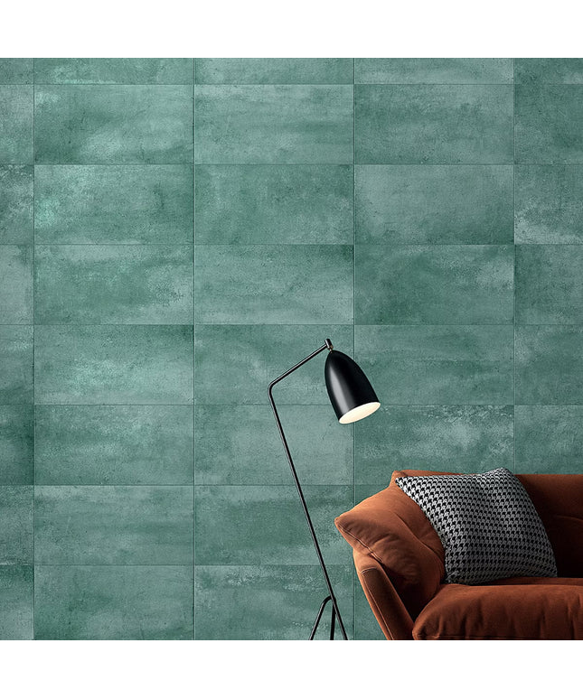 Green tiled wall with a brown sofa and black lamp
