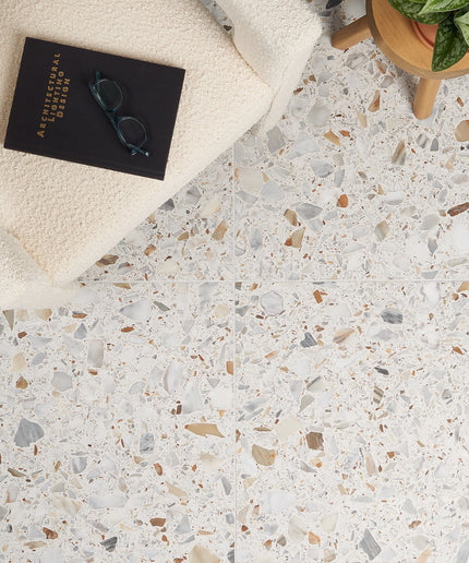 Terrazzo-style floor with a book, glasses, and plant on a white surface