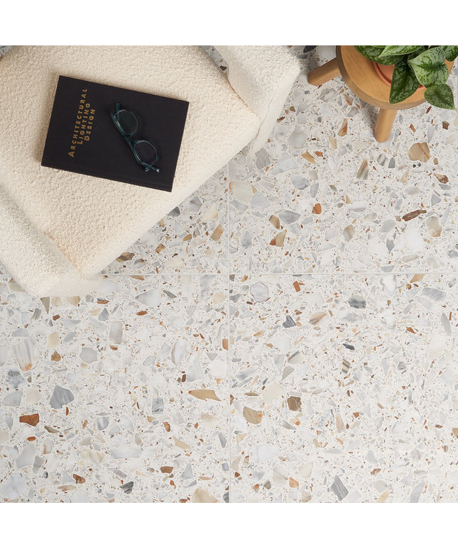 Terrazzo-style floor with a book, glasses, and plant on a white surface