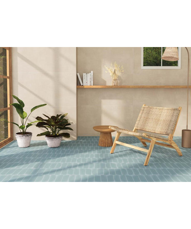 Modern interior with a wicker chair, potted plants, and a small table on a blue tiled floor.