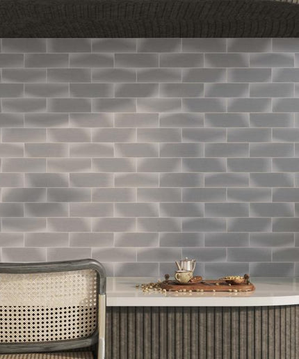Gray brick-patterned wall with a table and chairs in a modern interior setting.