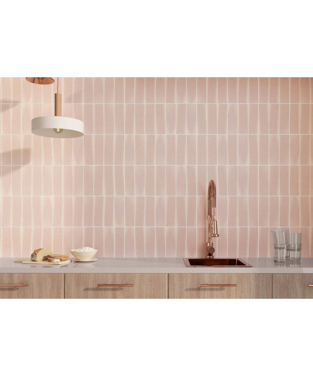Kitchen with pink tiled wall and wooden cabinets