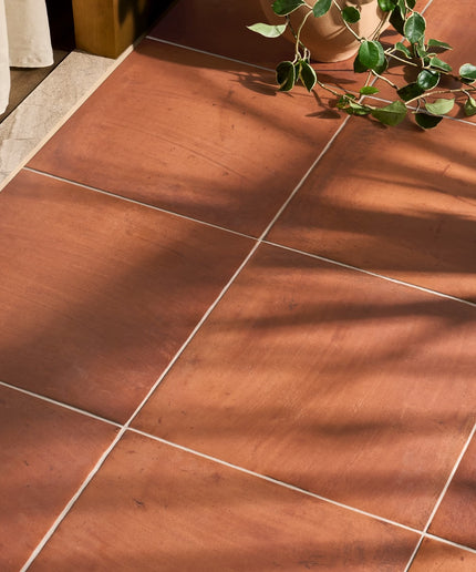 Terracotta 18x18 floor tiles with matte finish in natural sunlight, indoor decor setting