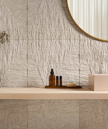 Bathroom vanity with textured tiles, a mirror, and decorative items.